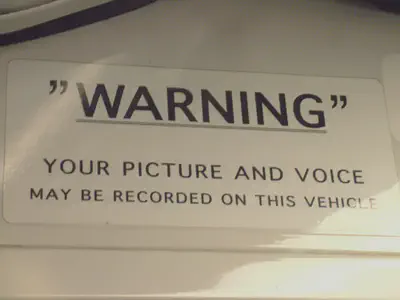 a sign says: 'warning' your picture and voice may be recorded on this vehicle